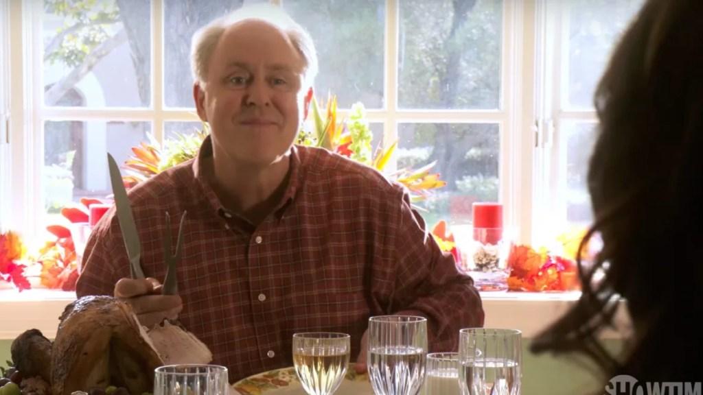 Arthur Mitchell (Trinity) à table, un couteau et une fourchette à découper à la main, lors du repas de Thanksgiving dans Dexter